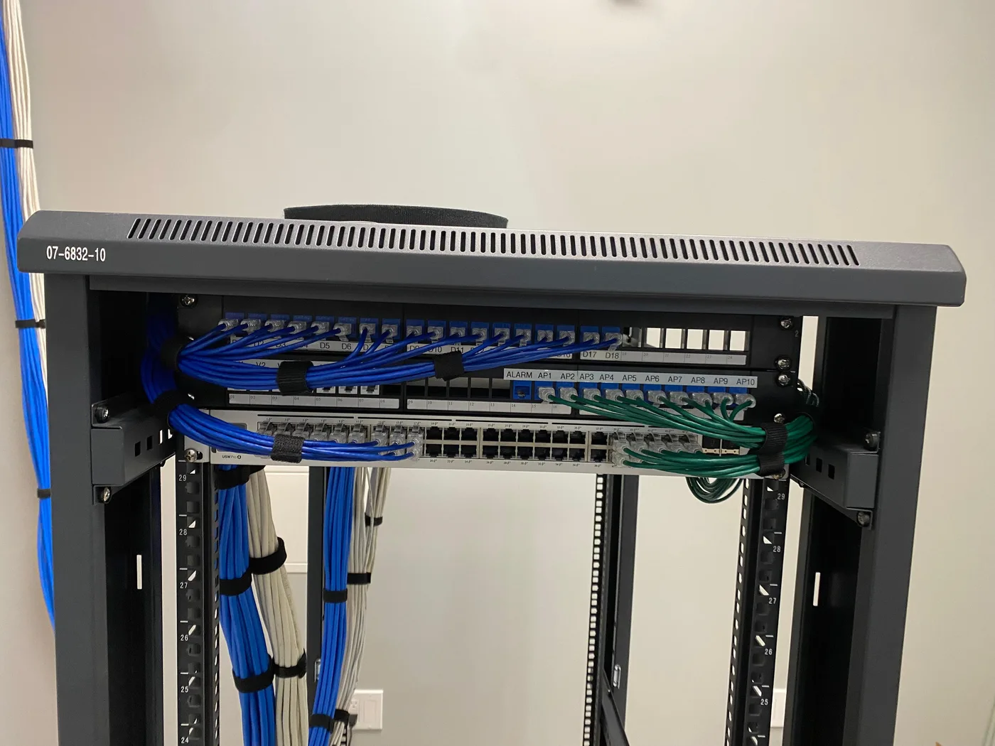 A close field view of labelled patch-panel connections and grouped network patch cables.